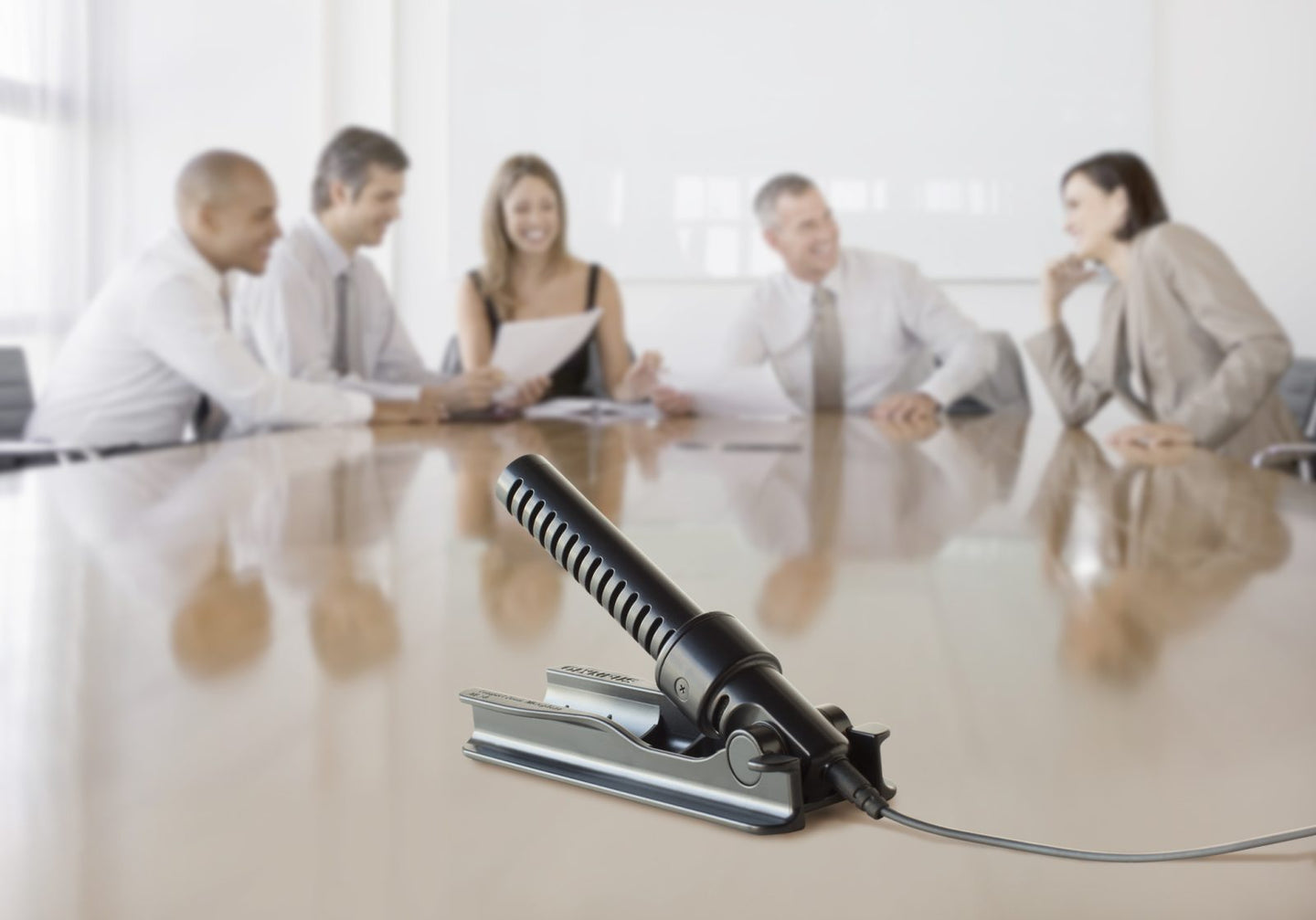 People sitting around a table with ME34 microphone in centre of table.