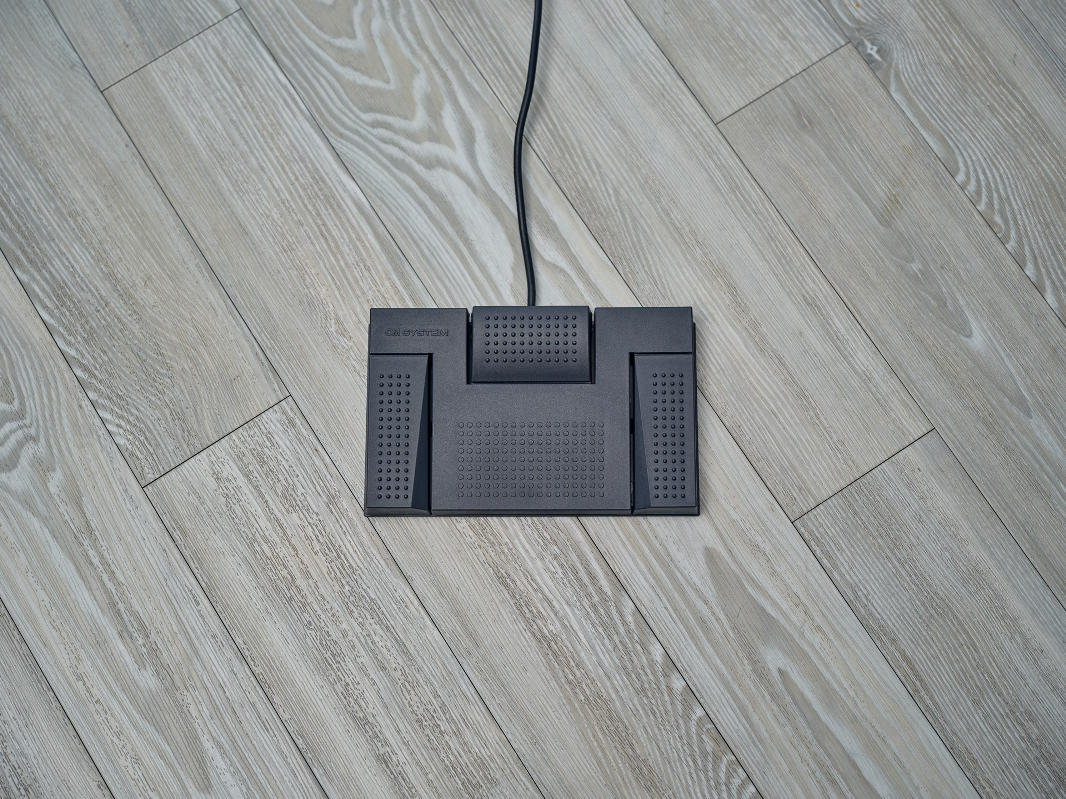 Aerial shot of OM System RS-28N three button foot pedal on vinyl floor