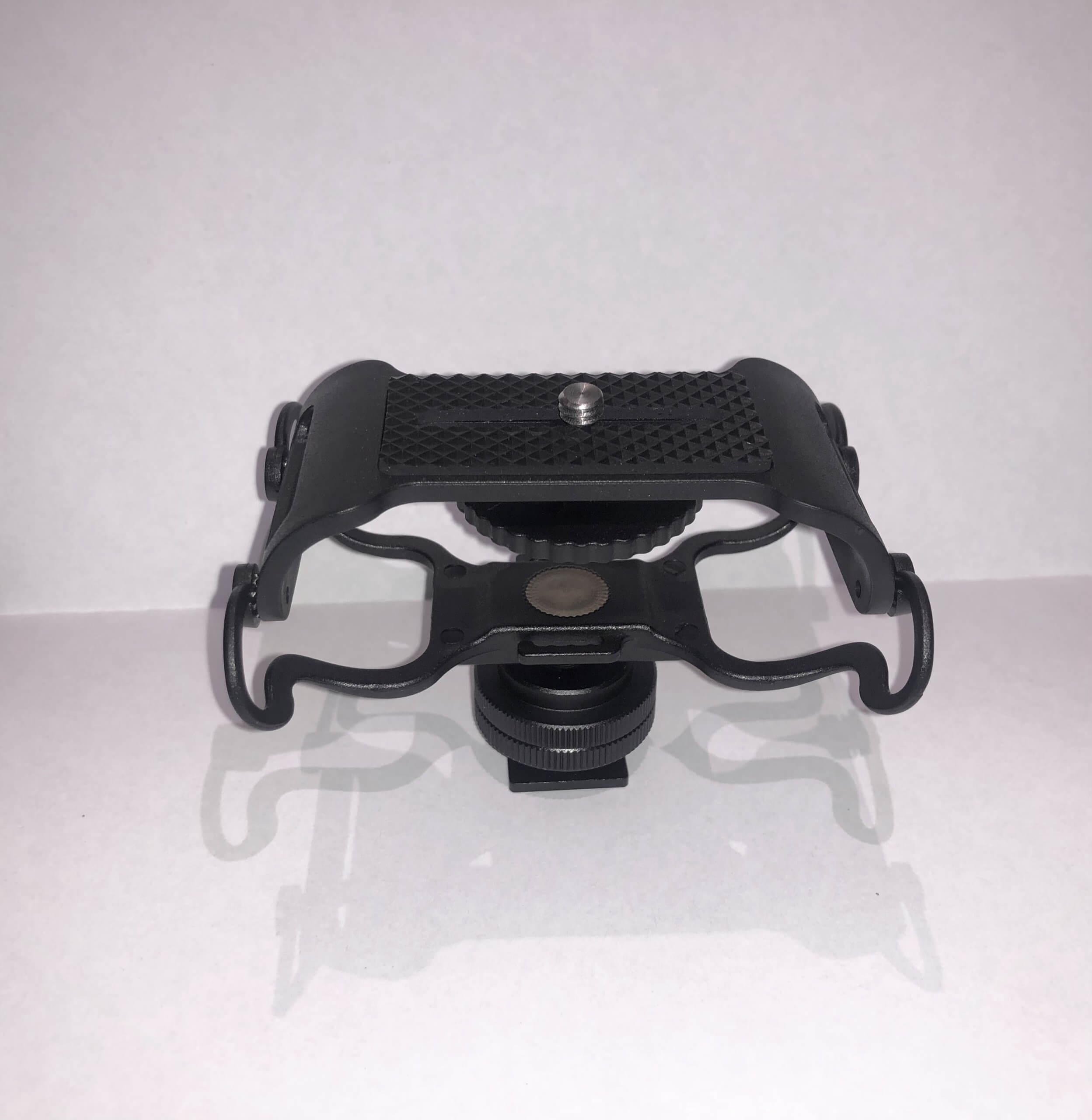 A black OM System SM-2 shock absorbing mount designed to attach a microphone to a camera hot shoe.