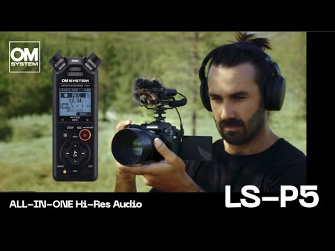 Man with headphones using Olympus video camera with OS-P5 recorder attached for recording audio and visual