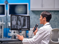 Radiologist  examining X rays and dictating into hand held OM System RecMic RM-4010N