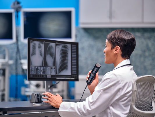 Radiologist  examining X rays and dictating into hand held OM System RecMic RM-4010N