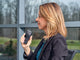 Woman standing by a window dictating with OM System DS-9100 dictaphone